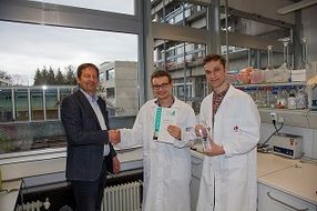 Der Stiftungsgründer Dr. Wolfgang Kuster übergibt den Förderpreis 2016 an die Studenten Johann Liebeton und Leon Werner.