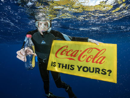 A Greenpeace diver holds a banner reading “Coca-Cola is this yours?” and a Coke bottle found adrift in the Great Pacific Garbage Patch. Even hundreds of kilometres from any inhabited land, plastic can be found polluting our environment.