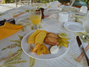 Breadfruit (wedges in on the upper left side of the plate) served for breakfast alongside starfruit and plantains.